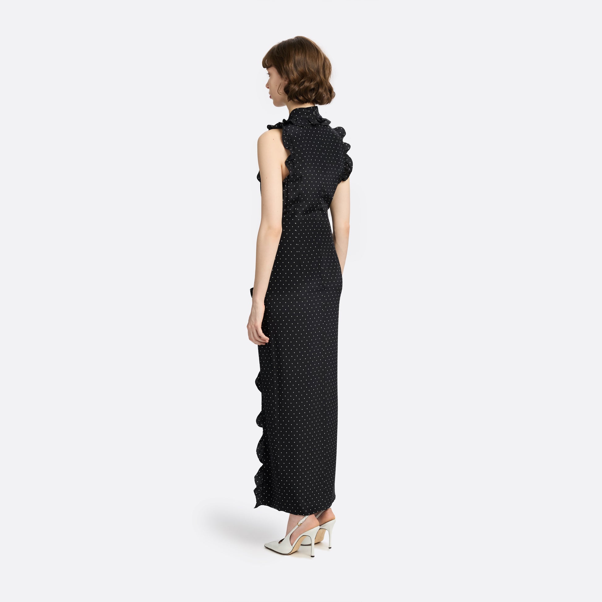Ivory diamond print on black silk crêpe de chine sleeveless midi dress with a high ruffled neckline, featuring button detail, side split and bow.