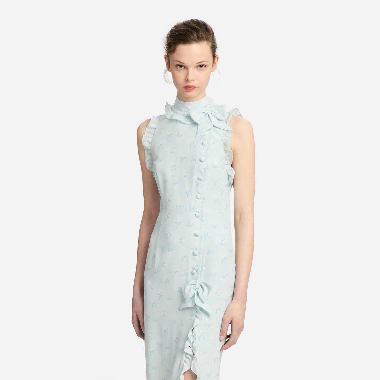 Pale blue floral print silk crêpe de chine sleeveless midi dress with a high ruffled neckline, featuring button detail, side split and bow.