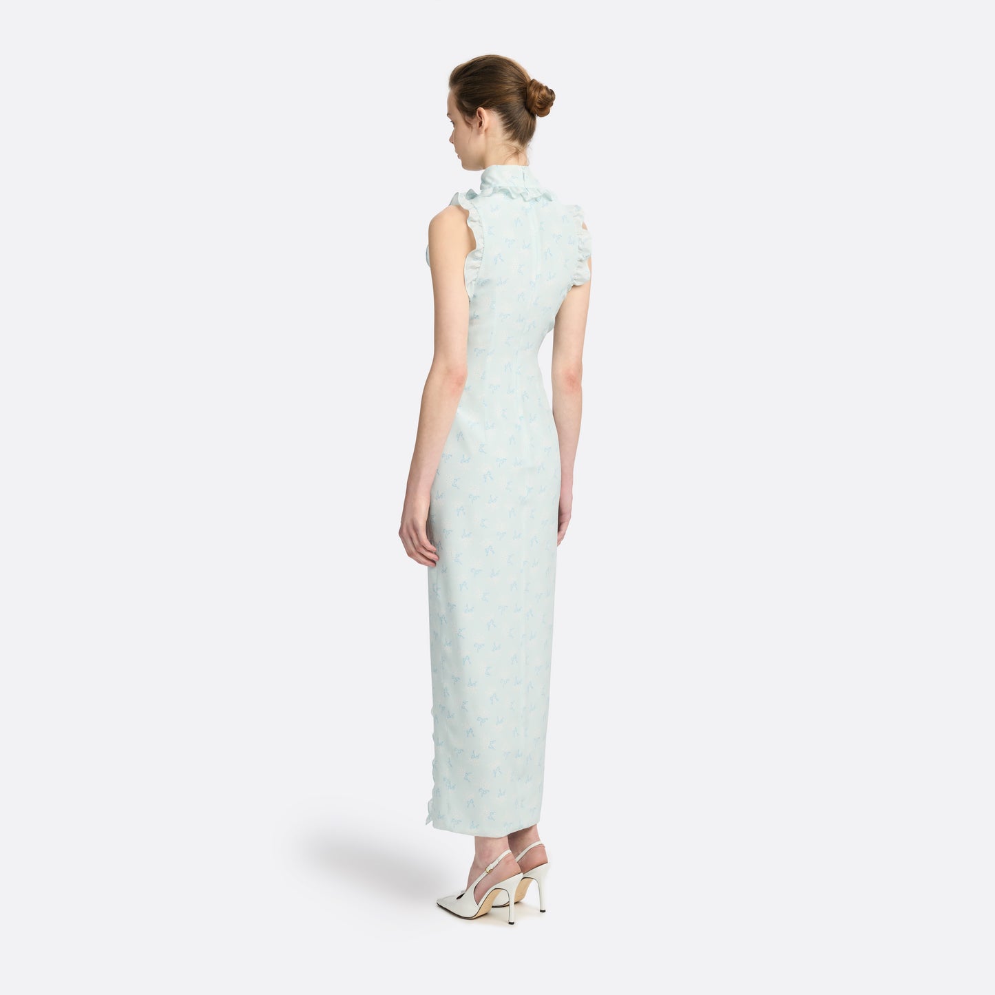 Pale blue floral print silk crêpe de chine sleeveless midi dress with a high ruffled neckline, featuring button detail, side split and bow.
