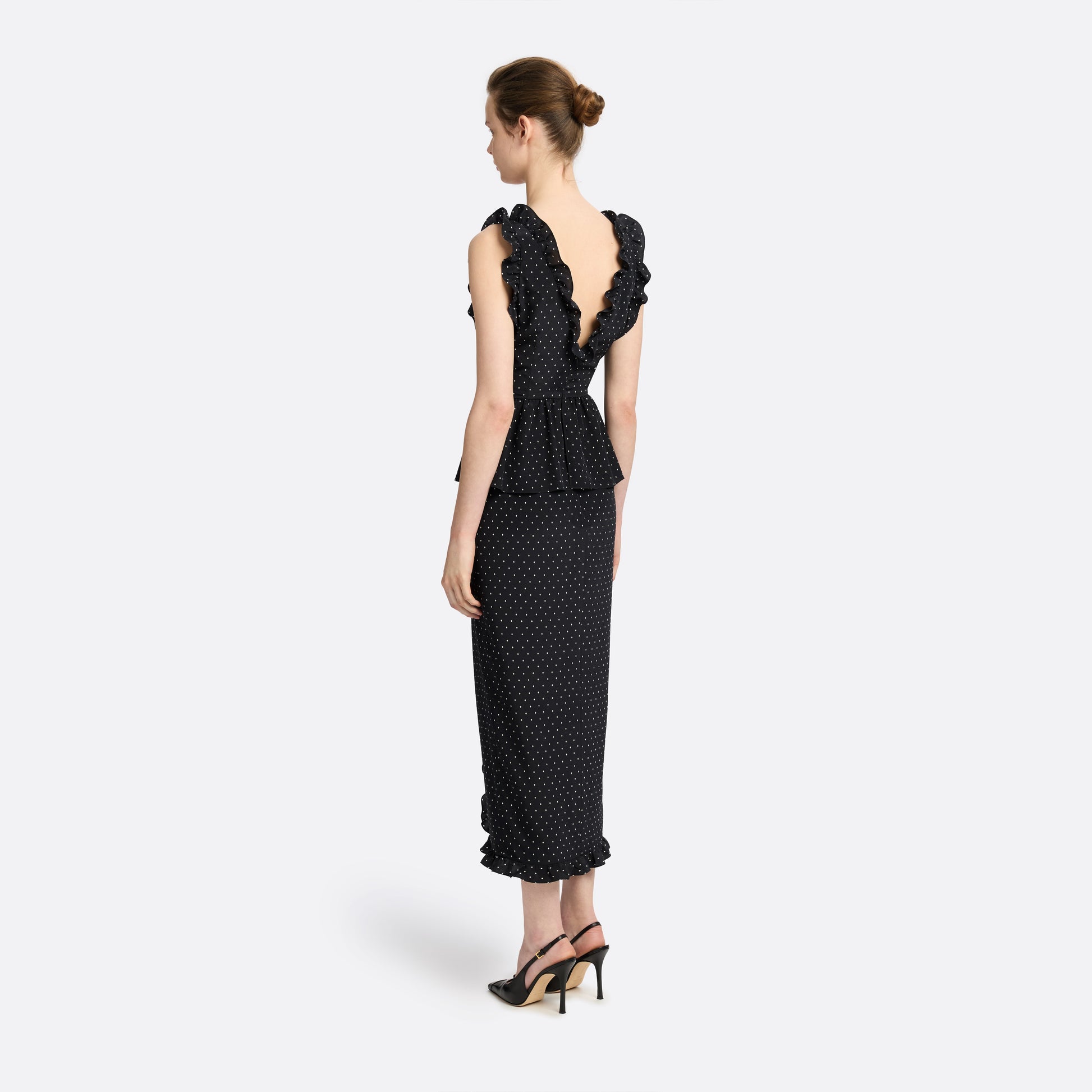 Ivory diamond print on black silk crêpe de chine midi dress with a deep V neckline and ruffled trims, featuring a peplum waist, front split and bow.