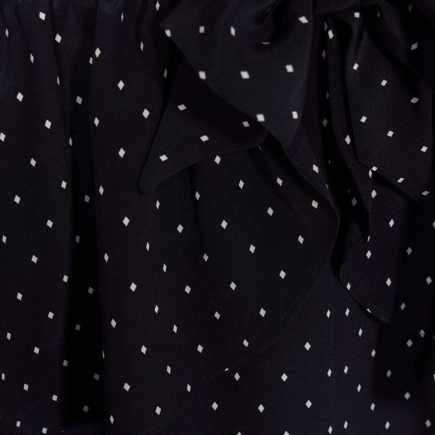 Ivory diamond print on black silk crêpe de chine midi dress with a deep V neckline and ruffled trims, featuring a peplum waist, front split and bow.