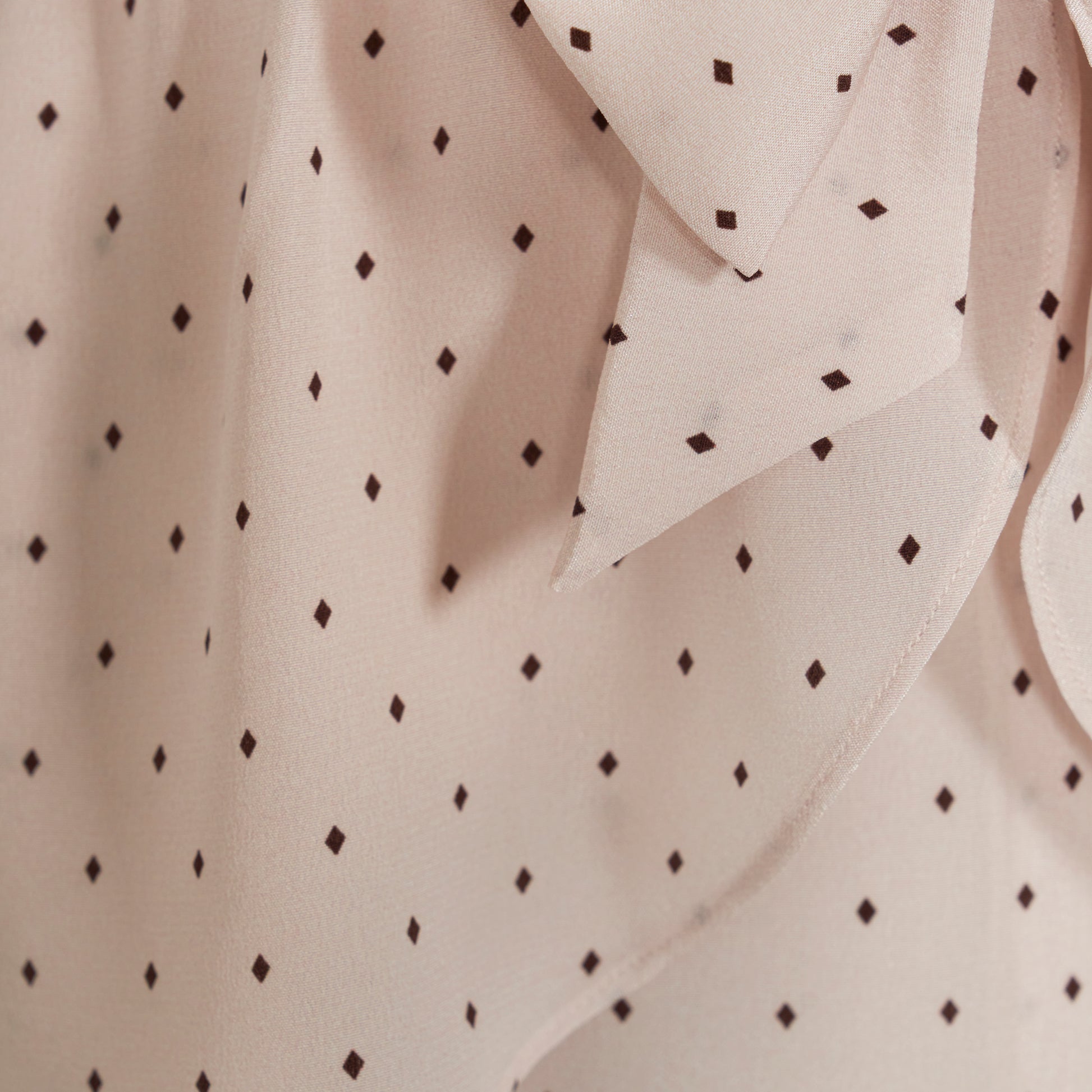 Brown diamond print on almond silk crêpe de chine midi dress with a deep V neckline and ruffled trims, featuring a peplum waist, front split and bow.
