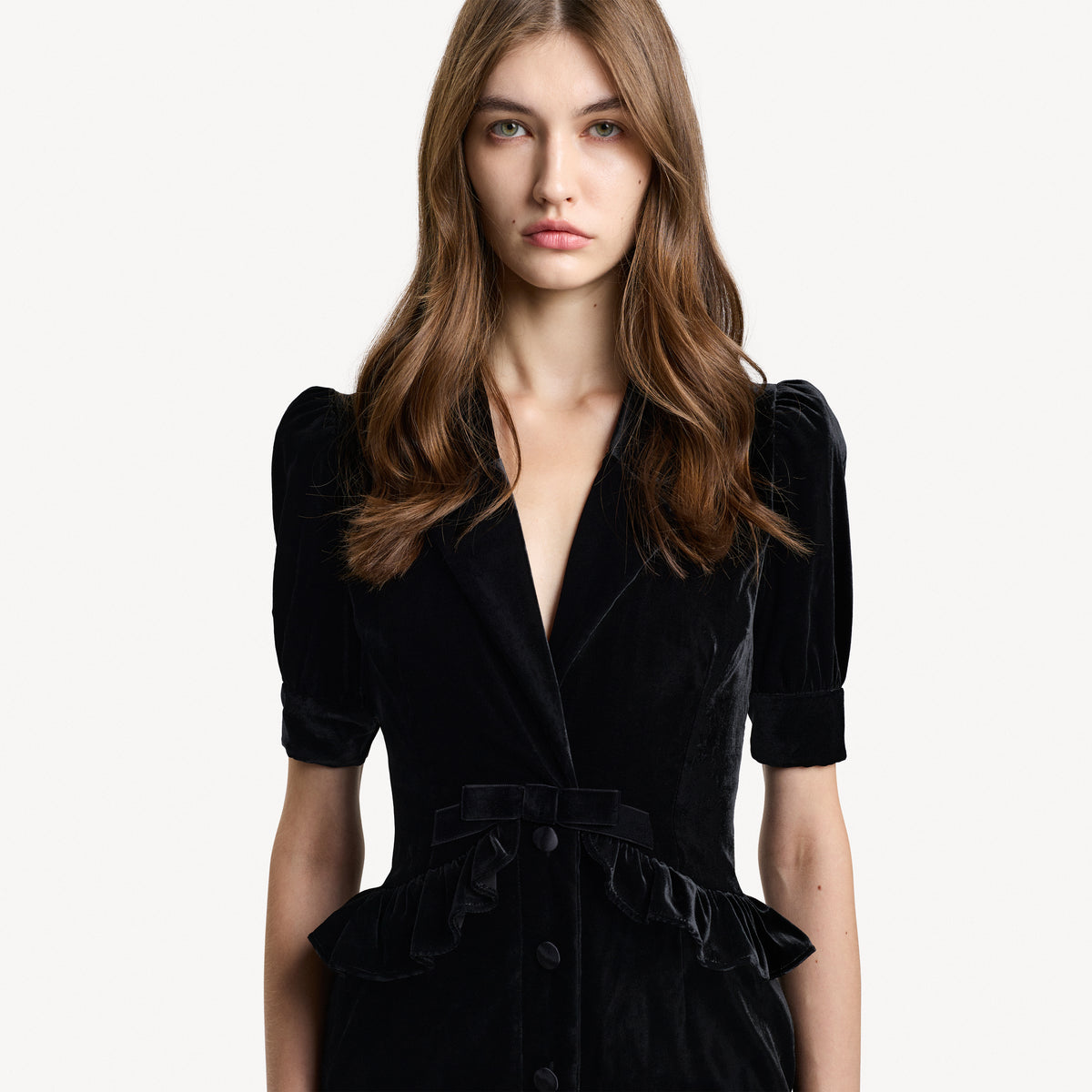 Black velvet evening dress with a v-neckline collar and a back-zip closure, featuring velvet ruffle trims.