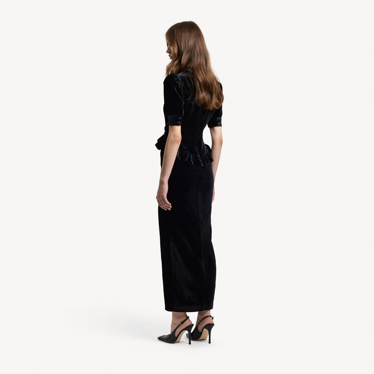 Black velvet evening dress with a v-neckline collar and a back-zip closure, featuring velvet ruffle trims.