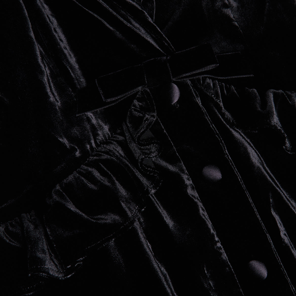 Black velvet evening dress with a v-neckline collar and a back-zip closure, featuring velvet ruffle trims.