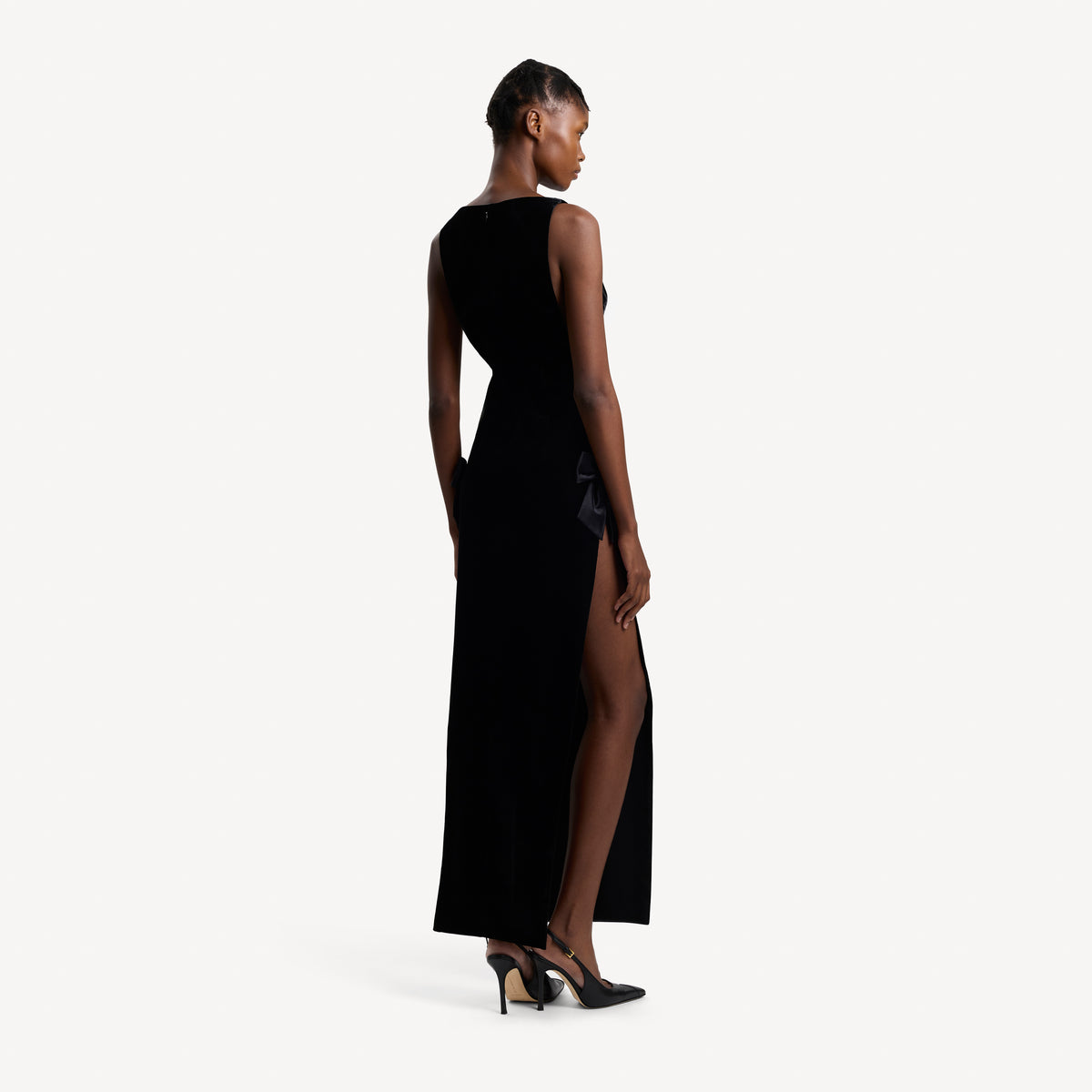 Black velvet evening dress with high side splits and silk bow details.
