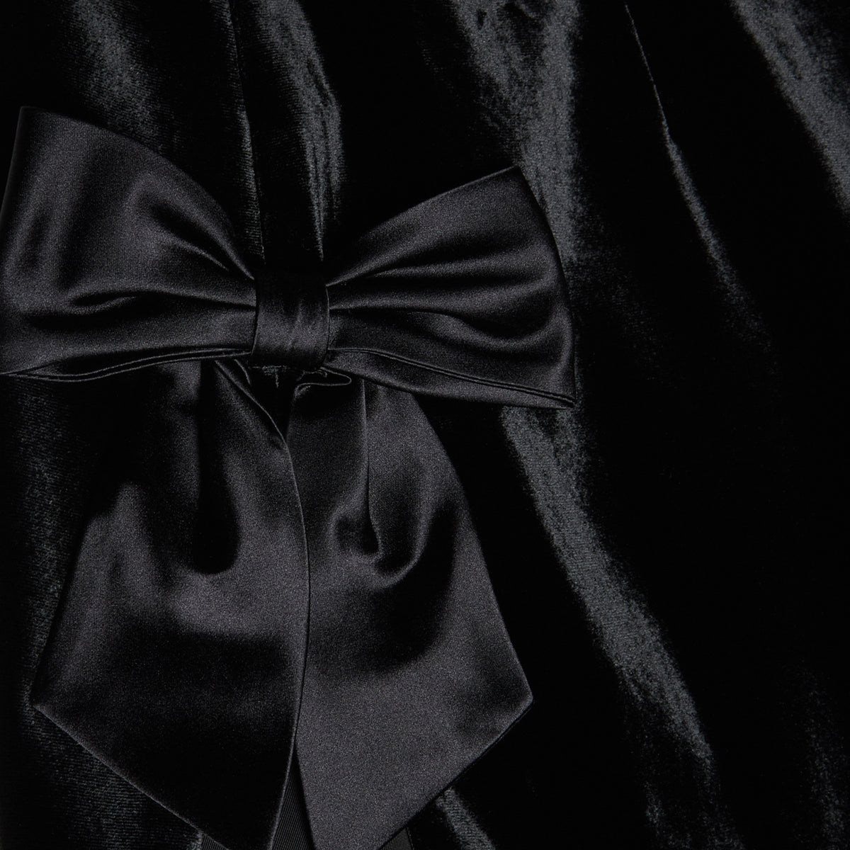 Black velvet evening dress with high side splits and silk bow details.